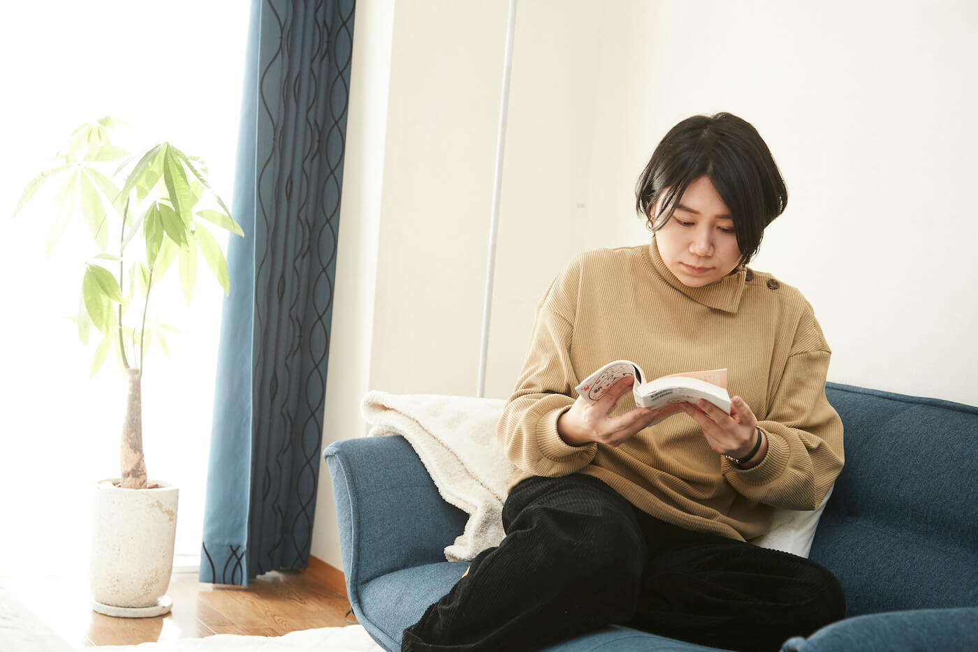 写真:里親に関する本を読む妻