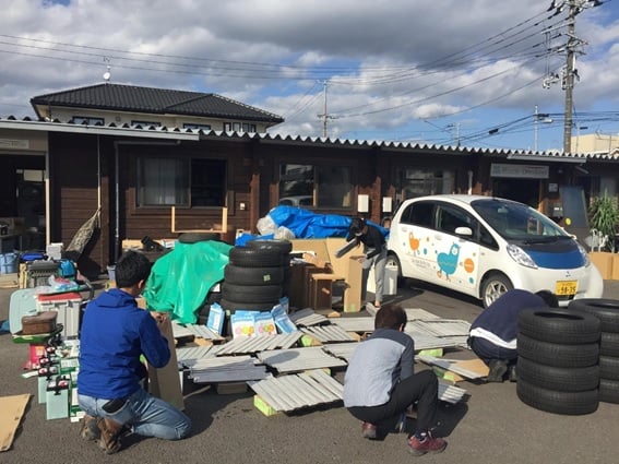 写真：事務所の前で浸水した備品などを並べる協会職員