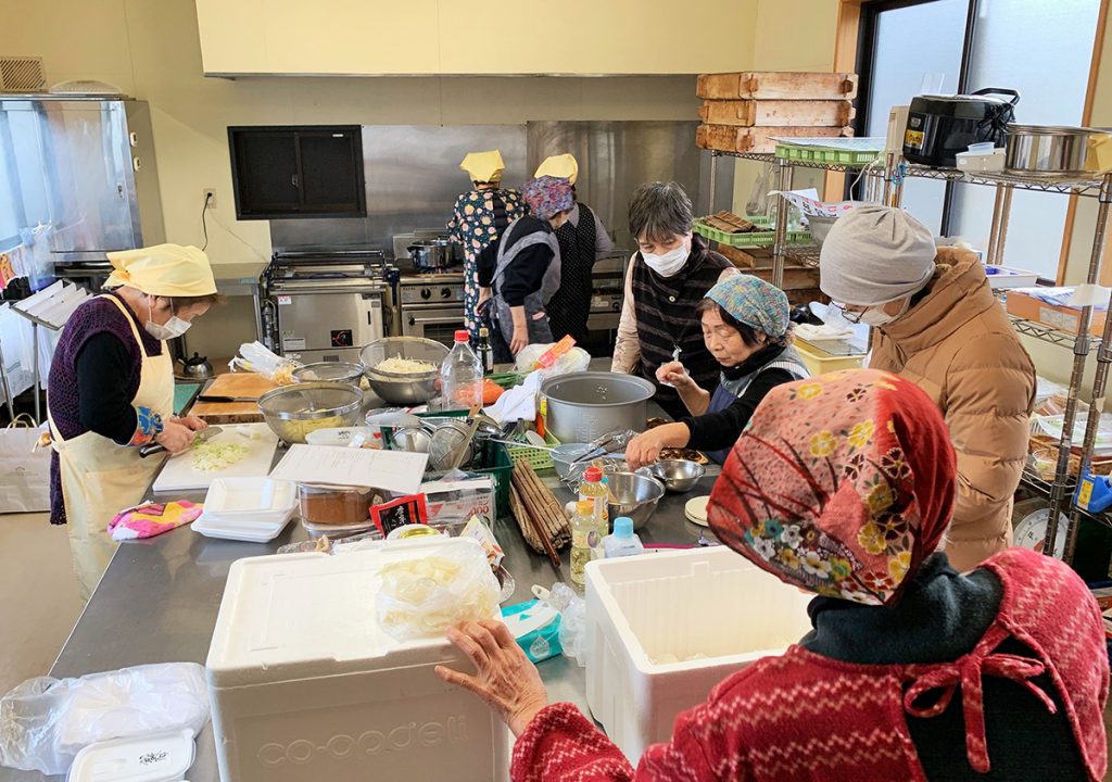写真：女性スタッフが中学生用の食事をつくる様子（1月28日、県NPOセンター提供）