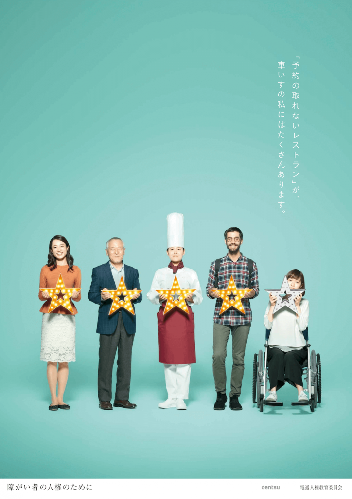 画像：「『予約のとれないレストラン』が、車いすの私にはたくさんあります。」というメインコピーの背景に、5つ星満点で、4つの点灯した星を持った健常者の女性、高齢者、シェフ、外国人と、1つの無点灯の星を持った車いすの女性が写ったポスター。下部に「障がい者の人権のために」「dentsu」「電通人権教育委員会」と記載