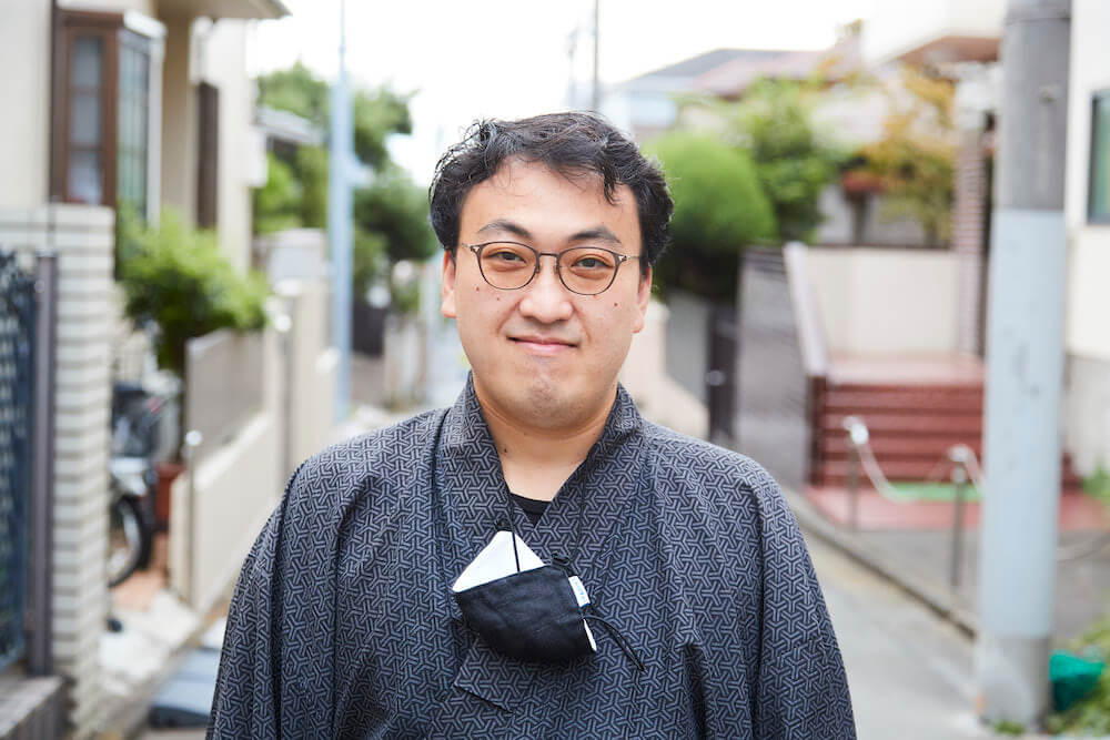 写真：路上でインタビューに応じる山口さん