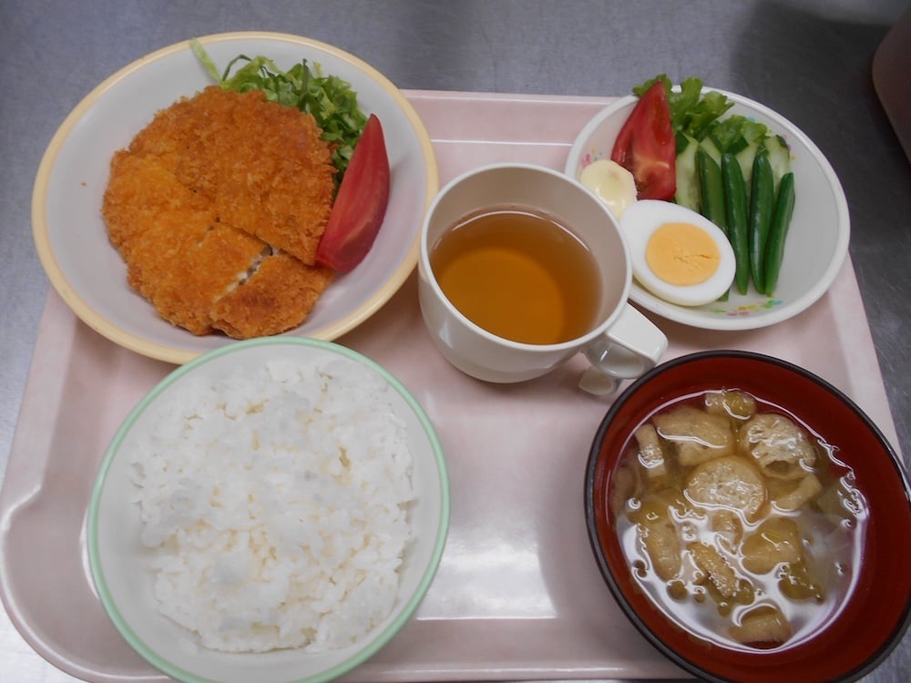 写真:左下から時計回りで、ごはん、フライ物、お茶、サラダ、お味噌汁