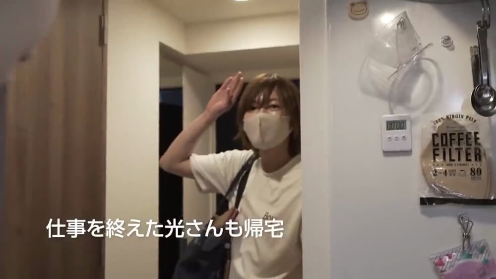 仕事を終えた光さんが玄関に立っている