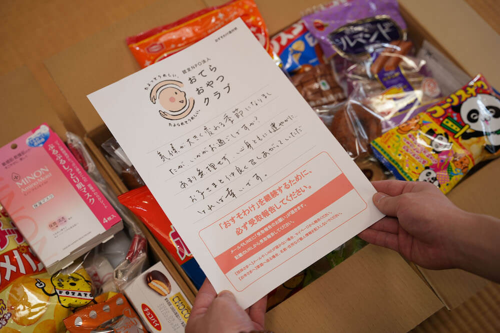 おてらおやつクラブのオリジナル便箋に書かれた支援側からの手紙:
気候が大きく変わる季節になりましたが、いかがお過ごしですか?あまり無理せず、心身ともに健やかにお子さまと仲良く召しあがっていただければ幸いです。
注意書き/「おすそわけ」を継続するために、必ず受け取り報告をしてください。メールやLINEに「受取報告のお願い」が届きます。記載のURLから受取報告してください。【団体さまへ】メールやLINEが届かない場合、マイページから報告ください。【お寺さまへ】家庭へ送る場合、名前・住所など個人情報を記入しないでください。