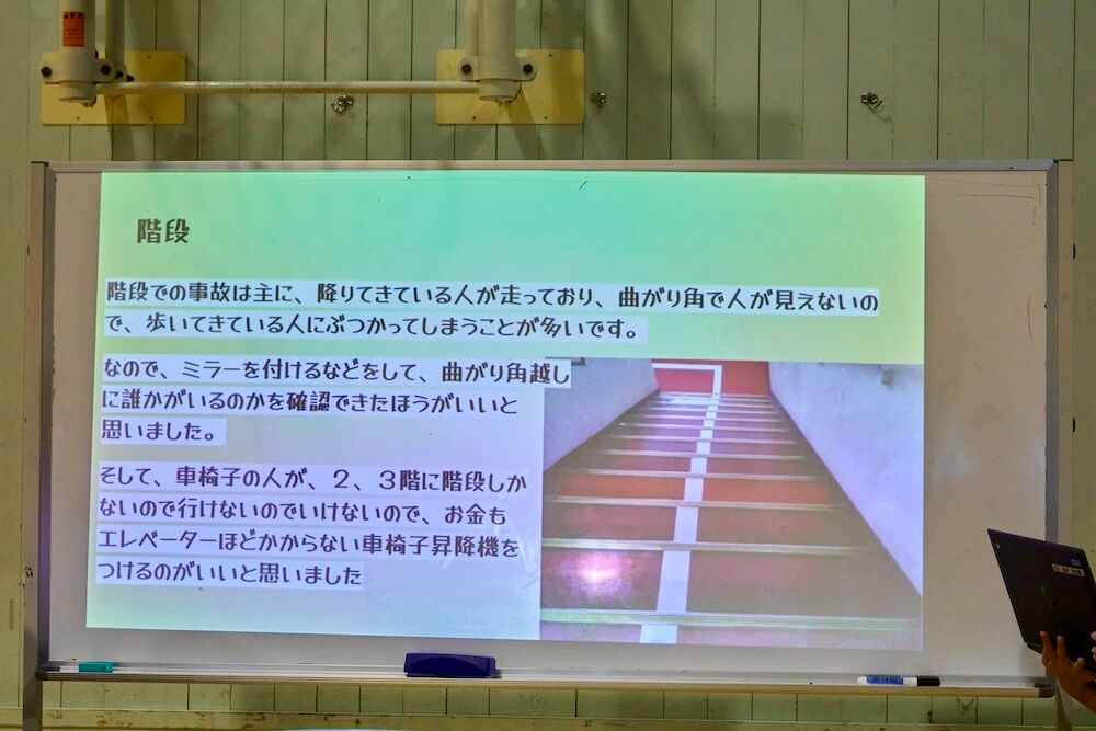 写真:大きなホワイトボードにプロジェクターで投影された児童たちのバリアフリー化アイデア