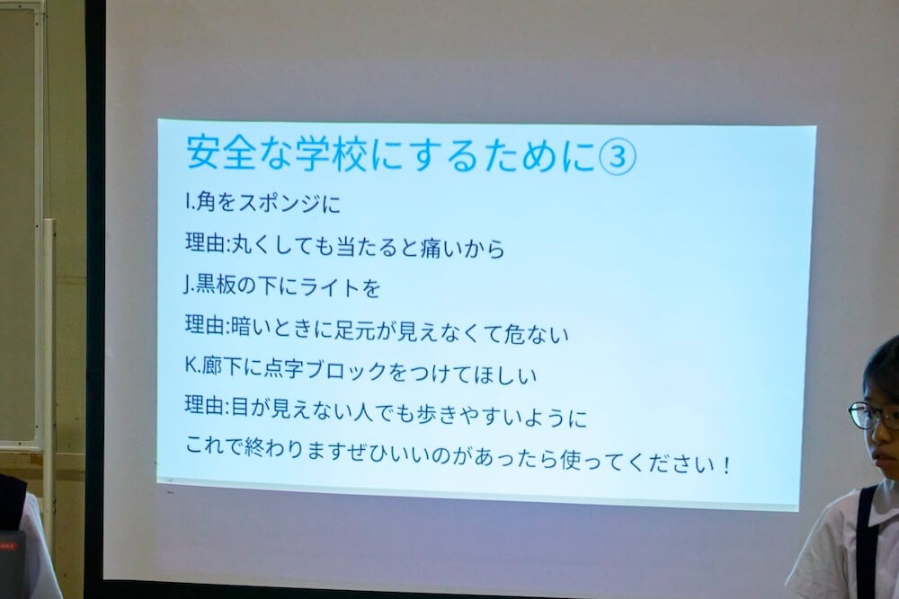 写真:大きなホワイトボードにプロジェクターで投影された児童たちのバリアフリー化アイデア