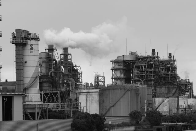 写真（イメージ）：煙突から煙を出す工場地帯