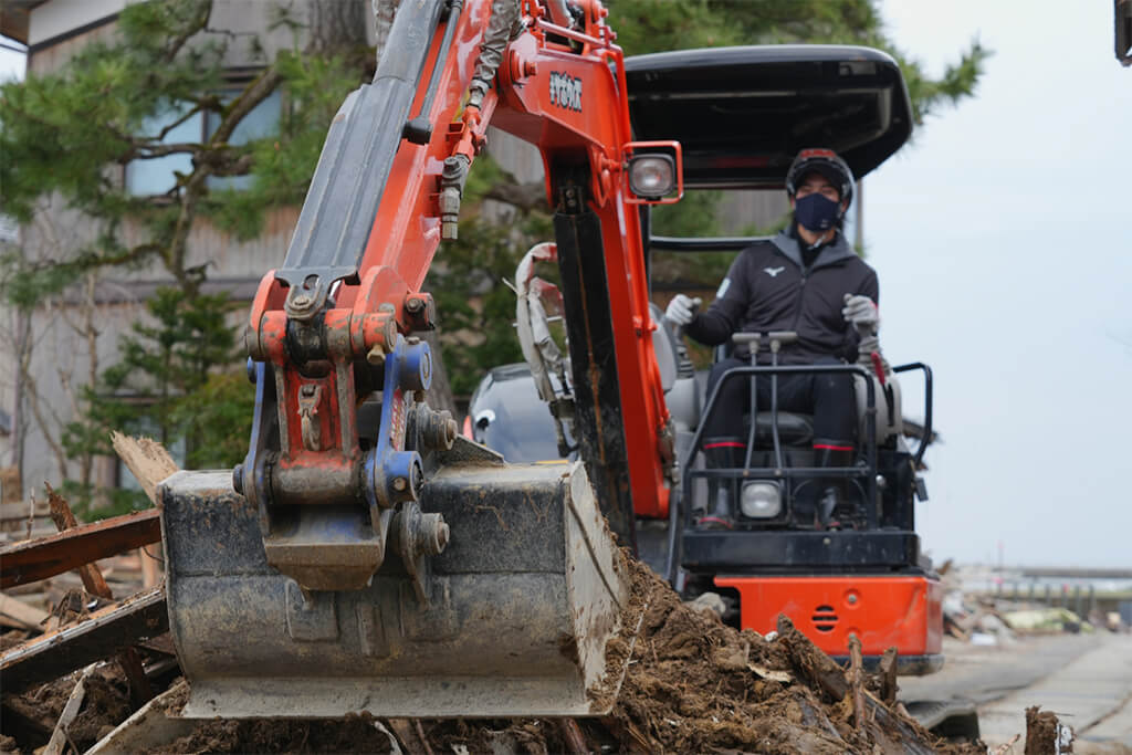 写真：小型重機を操縦し、活動を行うプロテニスプレイヤーの笹原龍氏