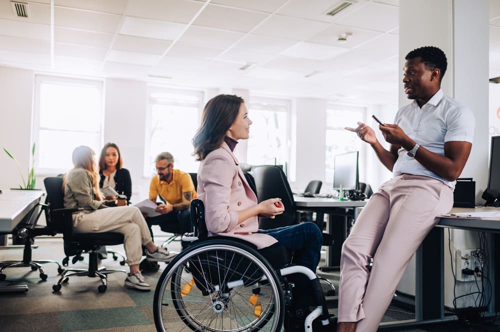 車椅子の人がオフィスで働いている