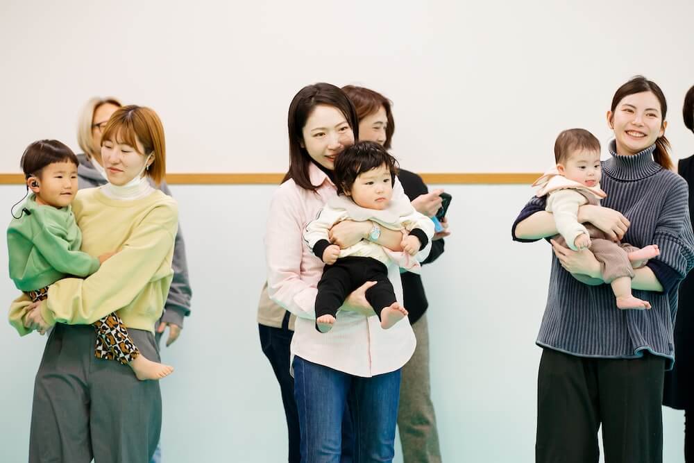 子どもを抱きながら「べびこめ」に参加するお母さんたち。笑顔で溢れている