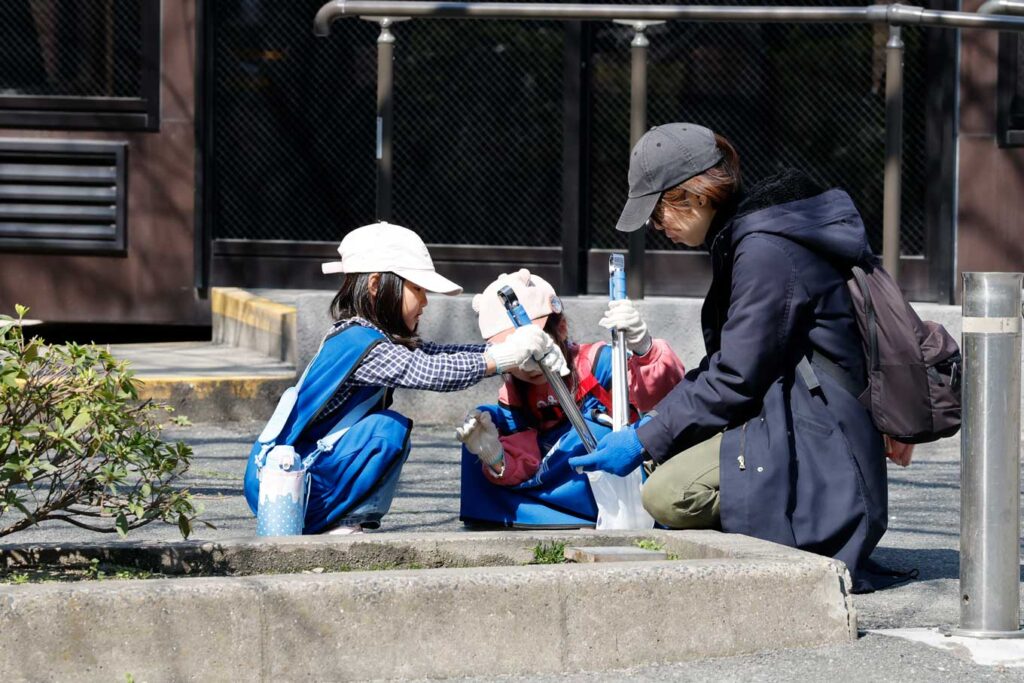 写真：SPOGOMI WORLDCUP エキシビションマッチ参加者の集合写真。画面前側に集められた大量のゴミがある。