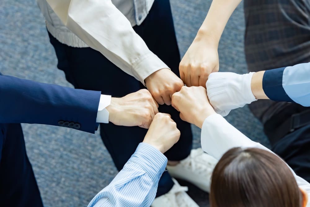 イメージ：手を合わせて気合いをいれる人々