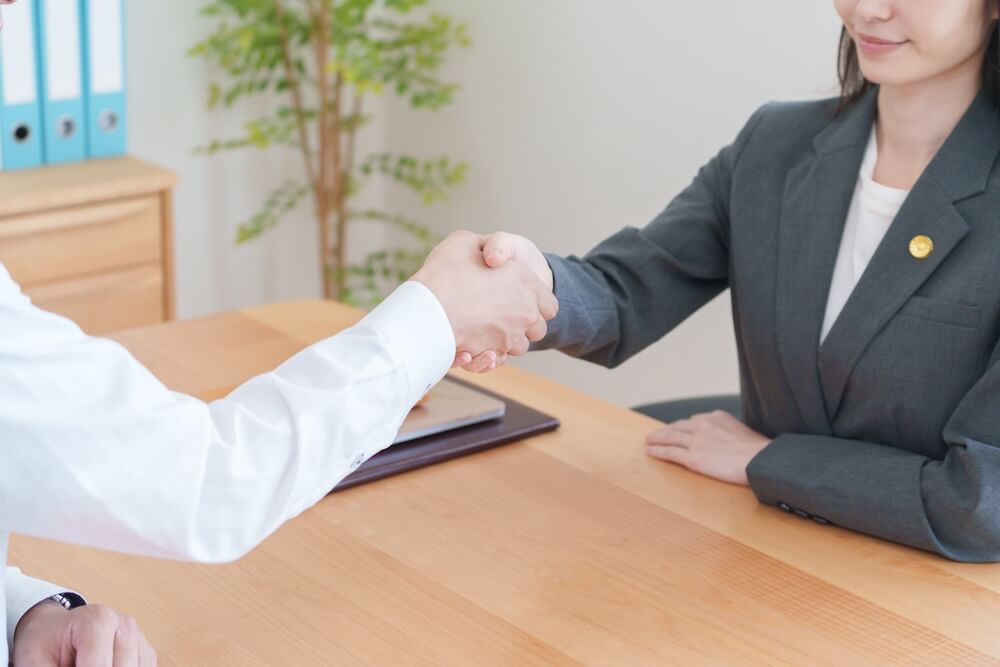 イメージ：弁護士と握手する依頼人