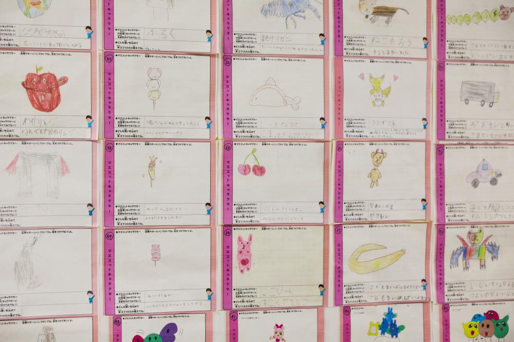 中野区内在住や在学の小中学生から公募したマスコットキャラクターの絵が壁にたくさん貼られている様子