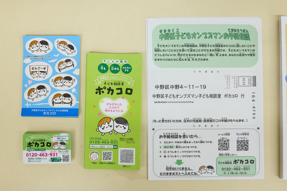 子どもたちに配布している、子ども相談室「ポカコロ」のシール、電話番号（0120-463-931）が記されたマグネット、資料と「中野区子どもオンブズマンお手紙相談」と記された相談用紙