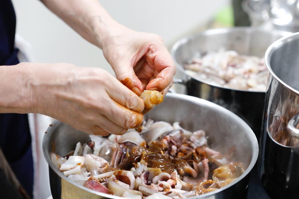イカの内臓を包んでいる皮を破っている様子