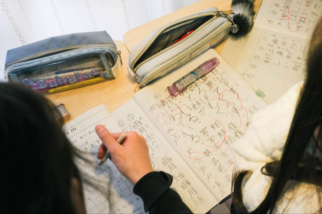 写真：居場所に来て宿題をする子どもたちの様子。